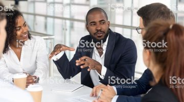 istockphoto-1139630453-2048×2048 Millennial employees gathered in boardroom for training, black boss ceo leader leading corporate team during seminar learning at modern office. Internship and leadership coaching and education concept